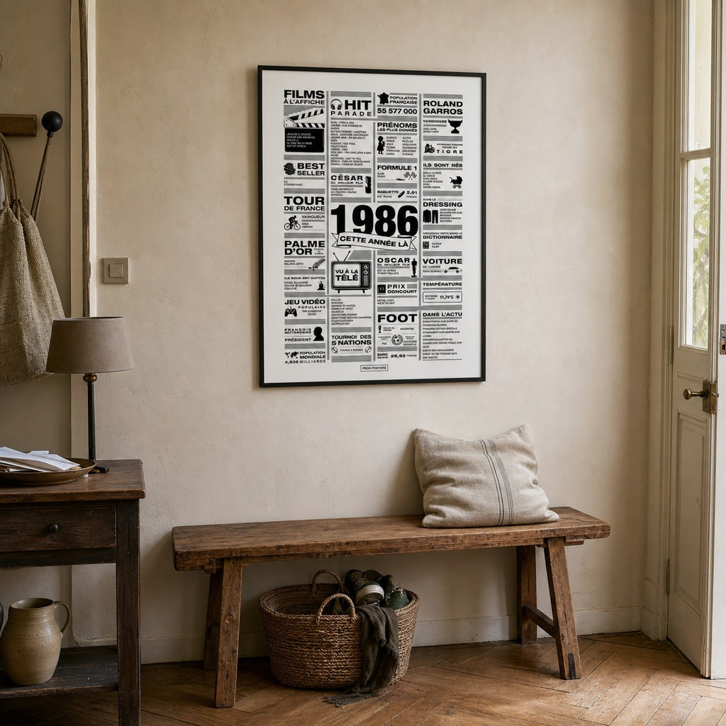 Affiche année 1986 encadrée dans une entrée rustique française avec banc en bois ancien et panier en osier, poster rétrospective année de naissance 1986, idée cadeau anniversaire, décoration murale rétro noir et blanc