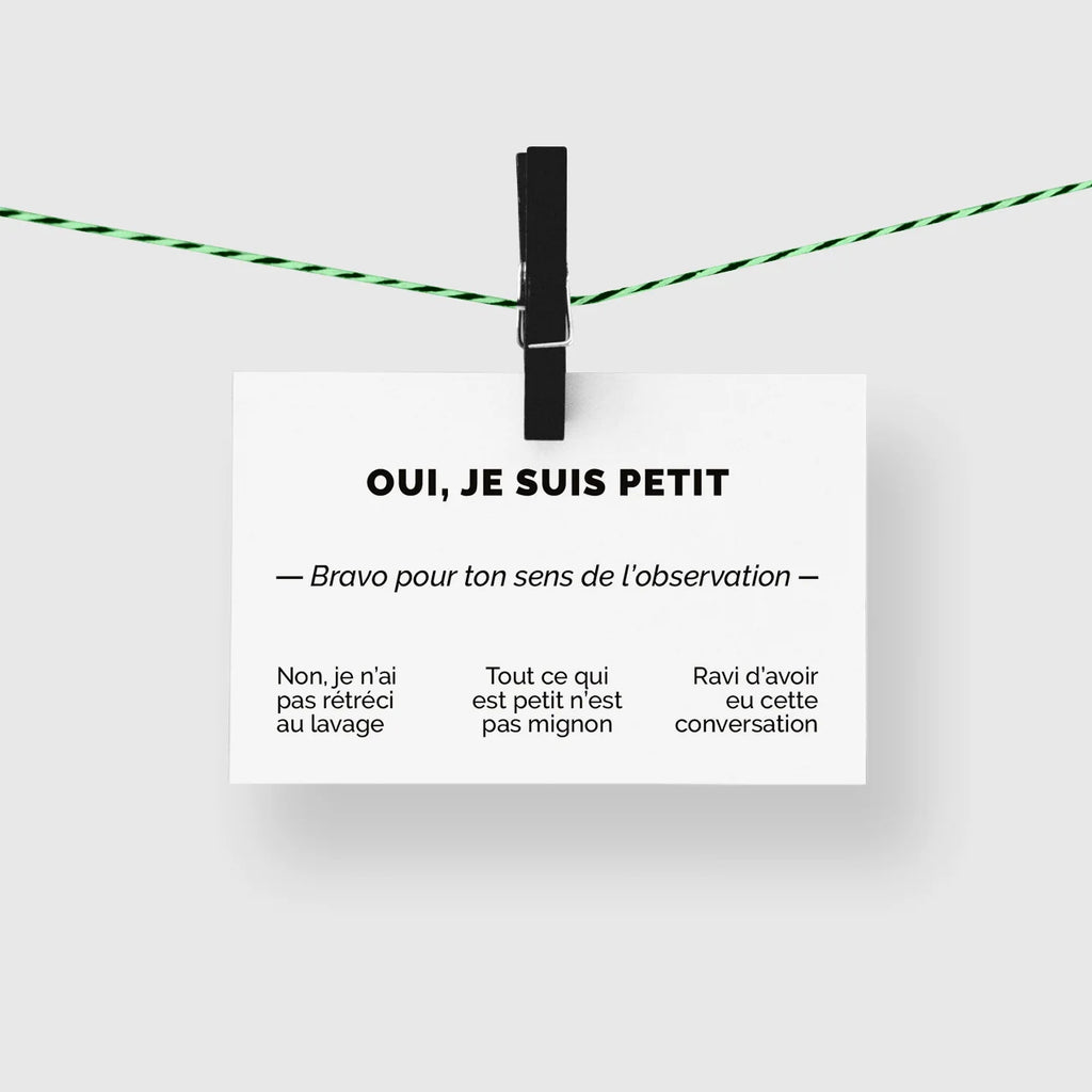 Carte de visite humour « Oui, je suis petit » suspendue à une corde à linge par une pince noire