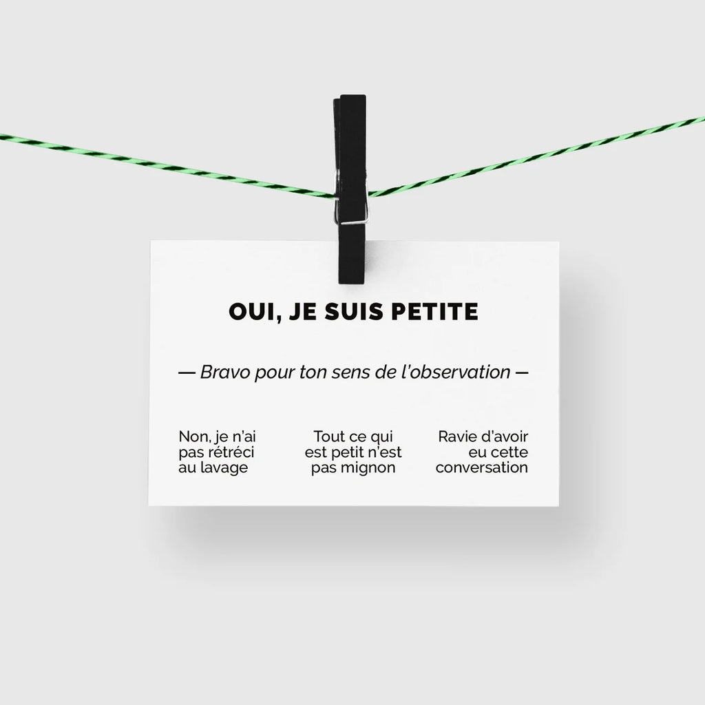 Carte de visite humour « Oui, je suis petite » suspendue à une corde à linge par une pince noire